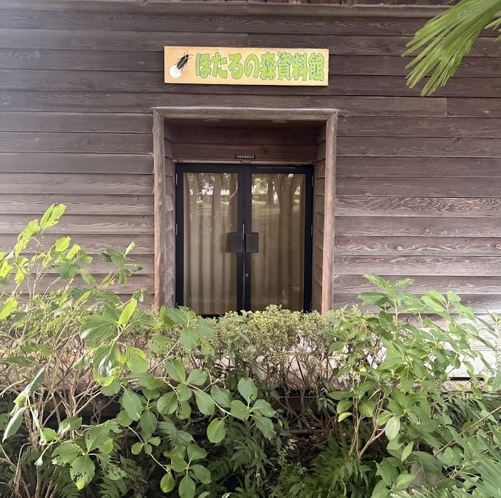 守山市民運動公園内にある「ほたるの森資料館」の入口。木造の建物の周囲には緑が広がっている。