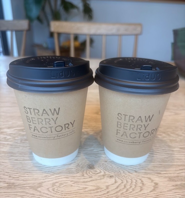 ストロベリーファクトリーのロゴが入った紙カップのコーヒー2杯